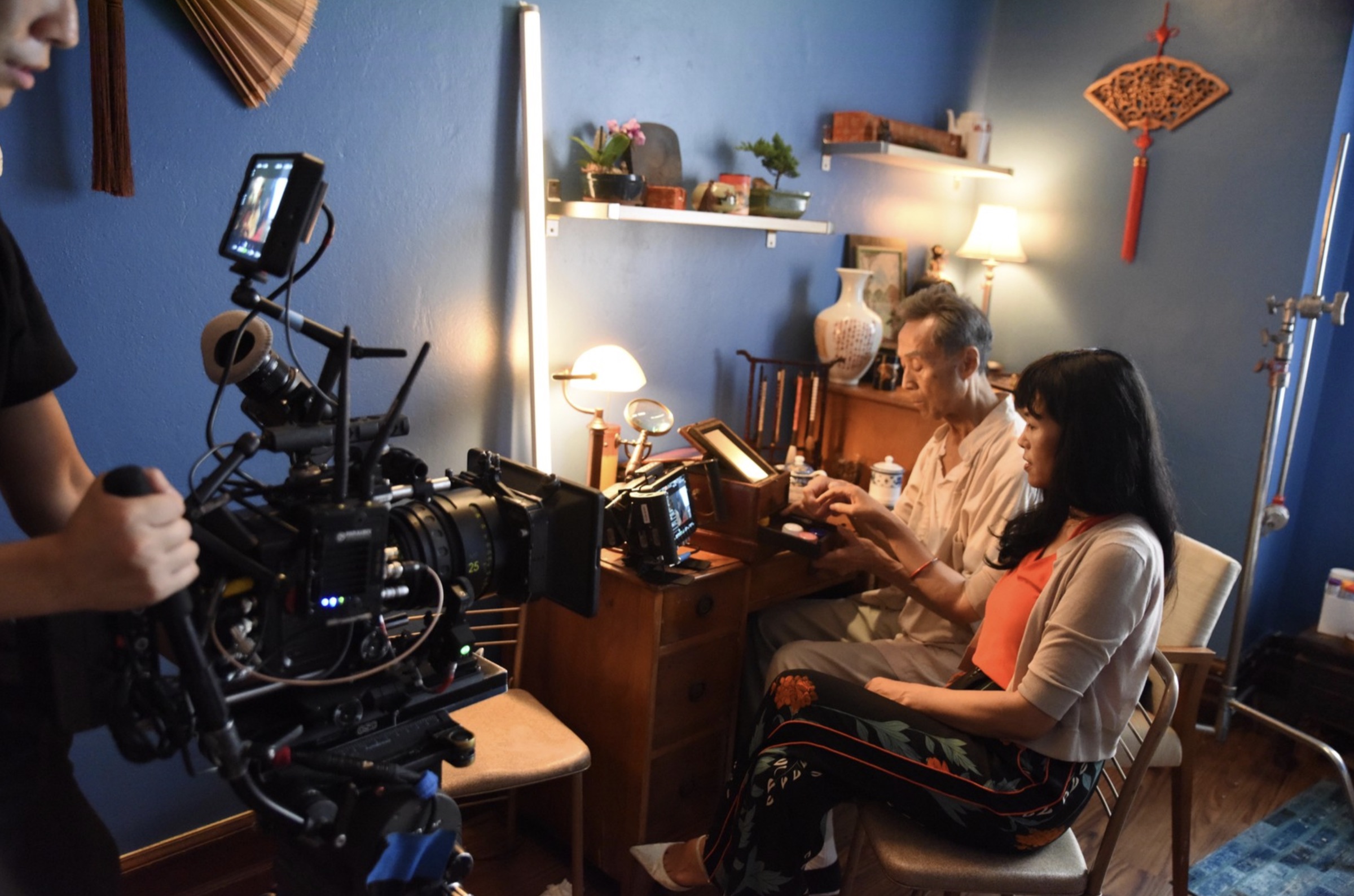 Grace Chang directing on set with a cinema camera filming two actors