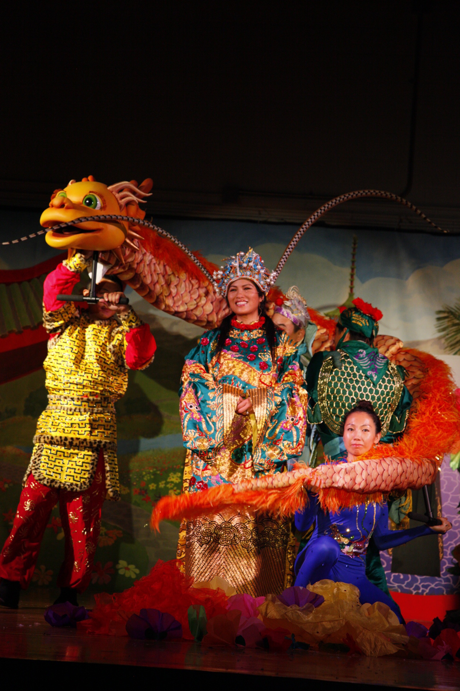 Grace Chang on stage in costume with a giant golden dragon puppet