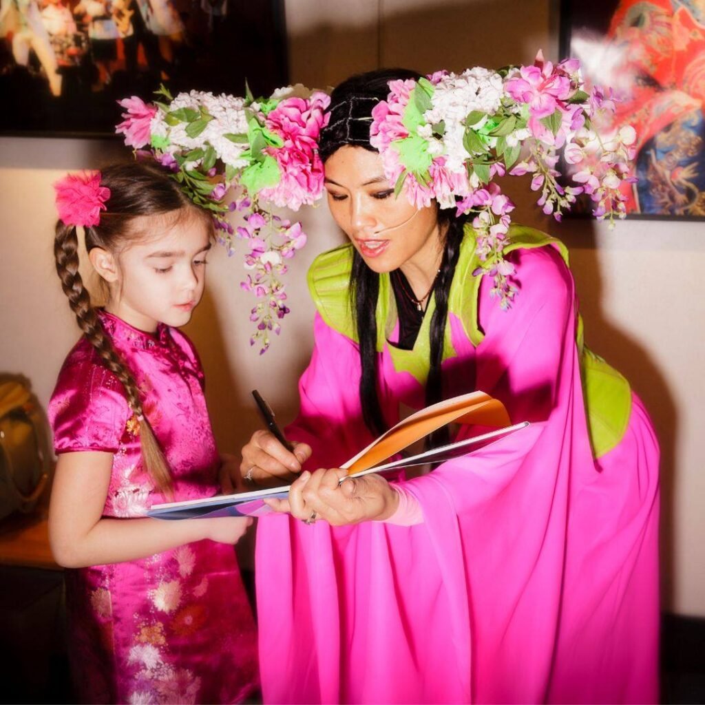 Grace Chang signing books for a young reader at a public event